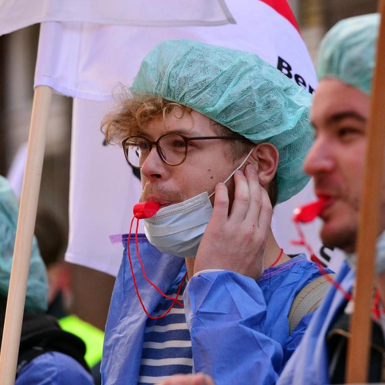Streikende Pflegerinnen und Pfleger protestieren vor der Charité vor Corona.
