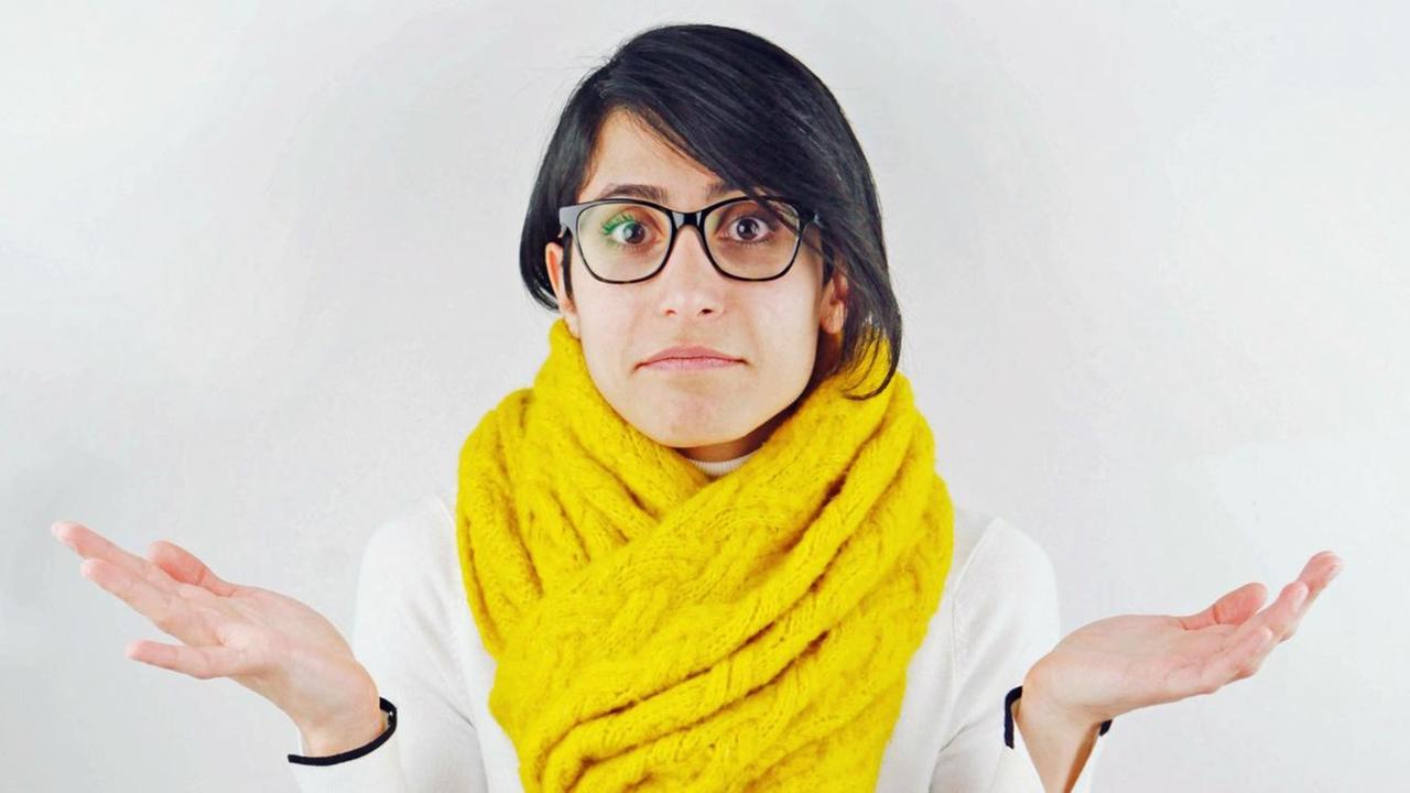 Eine Frau schaut in die Kamera und hebt die Hände fragend nach oben Eine Frau schaut in die Kamera und hebt die Hände fragend nach oben