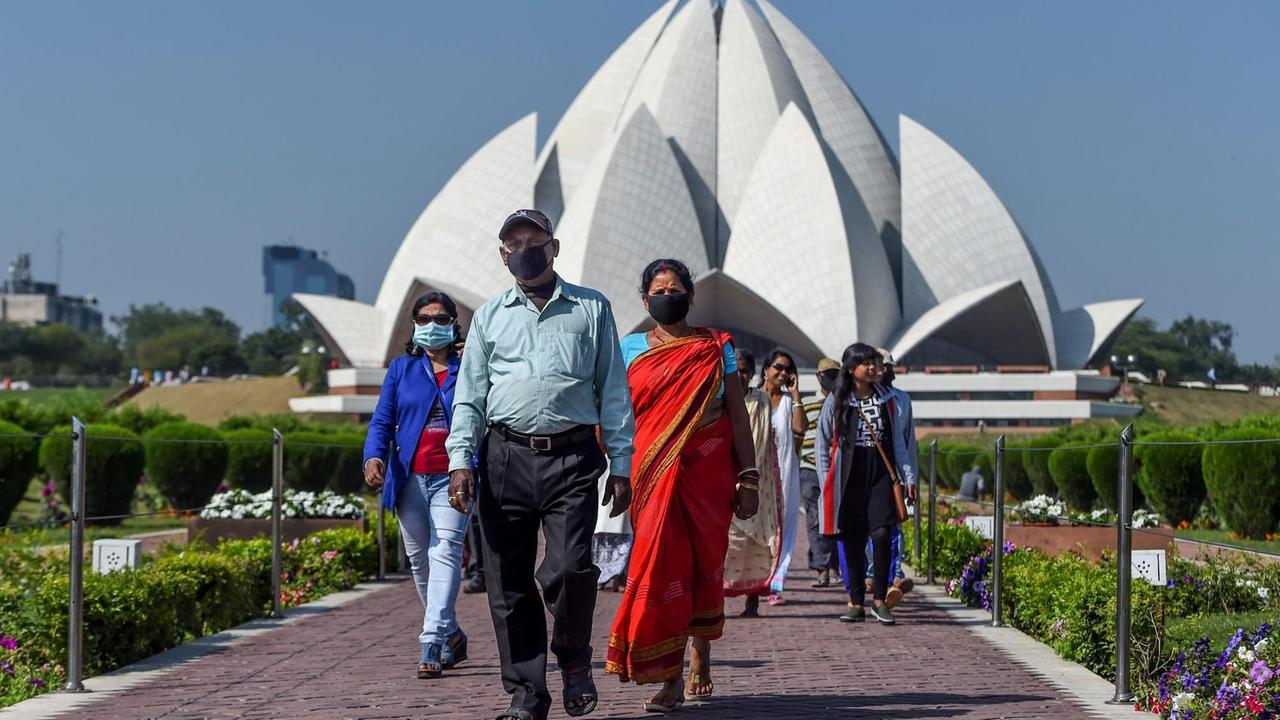 Besucher mit Mundschutz beim Lotus Tempel in Neu Delhi. 