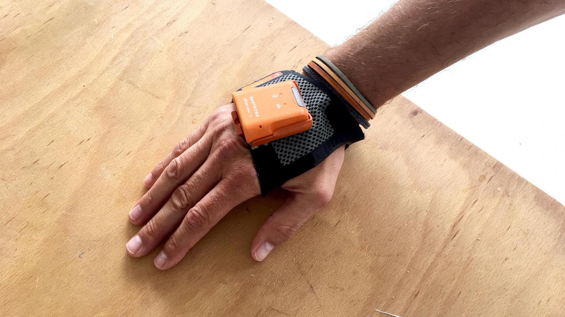 Ein Proglove Scanner-Handschuh, der an einer Hand befestigt ist. Ein Proglove Scanner-Handschuh, der an einer Hand befestigt ist.