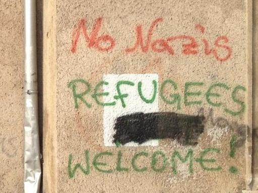 Unbekannte haben "Refugees not welcome" gesprayet, andere haben das "not" durchgestrichen.