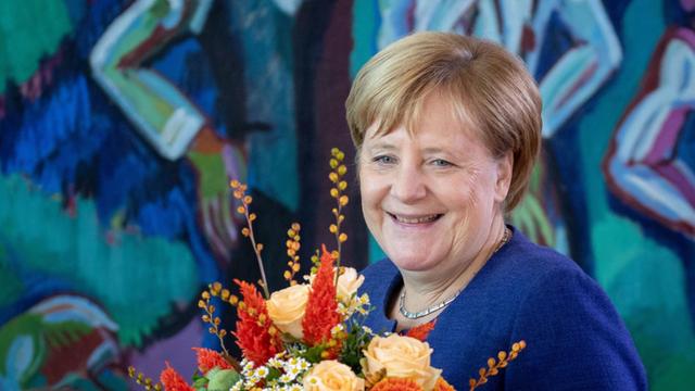 Bundeskanzlerin Angela Merkel (CDU) hält zu Beginn der Sitzung des Bundeskabinetts im Bundeskanzleramt einen Blumenstrauß in der Hand. Der Bundesminister für Verkehr und digitale Infrastruktur, Scheuer, bekam die Blumen zum Geburtstag.
