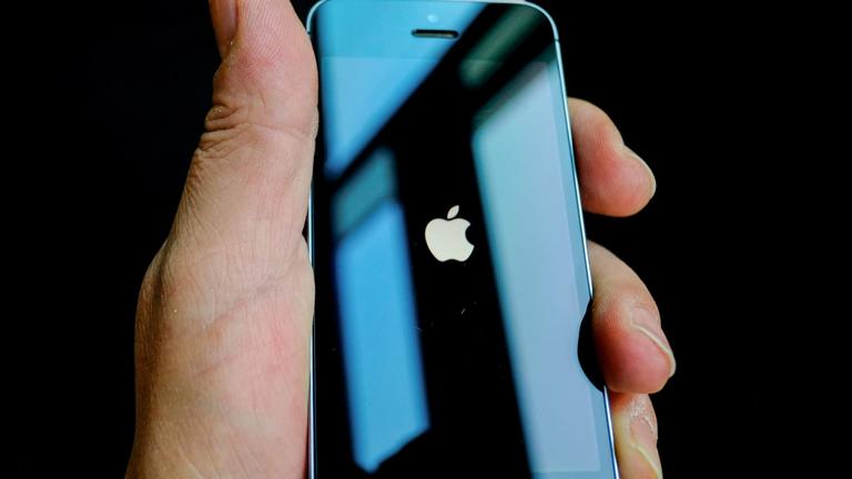 Eine Hand hält ein schwarzes iPhone. Auf dem Display ist das Apple-Logo, ein weißer Apfel, zu sehen.