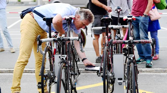 Ein UCI-Kommissar testet Räder bei der Tour de Suisse 2017 auf versteckte Motoren.