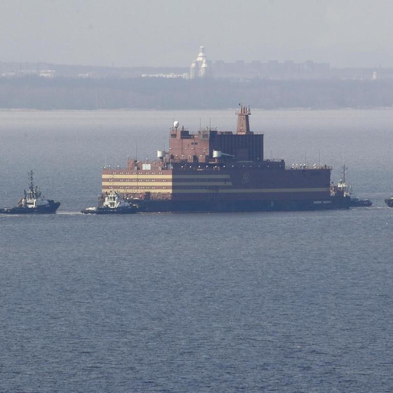Das Bild zeigt das umstrittene "Schwimmende Atomkraftwerk" Russlands, die "Akademik Lomonossow", die hier im Wasser von Beibooten eskortiert wird.