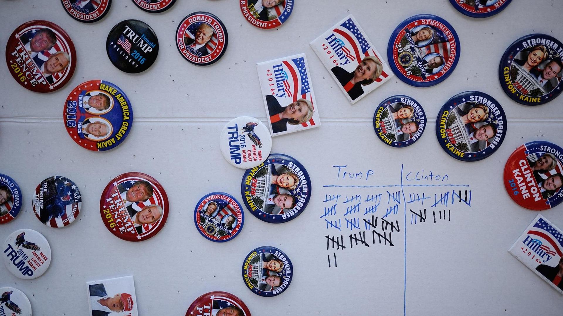 Magnete der Demokraten und der Republikaner kleben an einer Wand, daneben eine Strichliste über verkaufte Buttons. Magnete der Demokraten und der Republikaner kleben an einer Wand, daneben eine Strichliste über verkaufte Buttons.