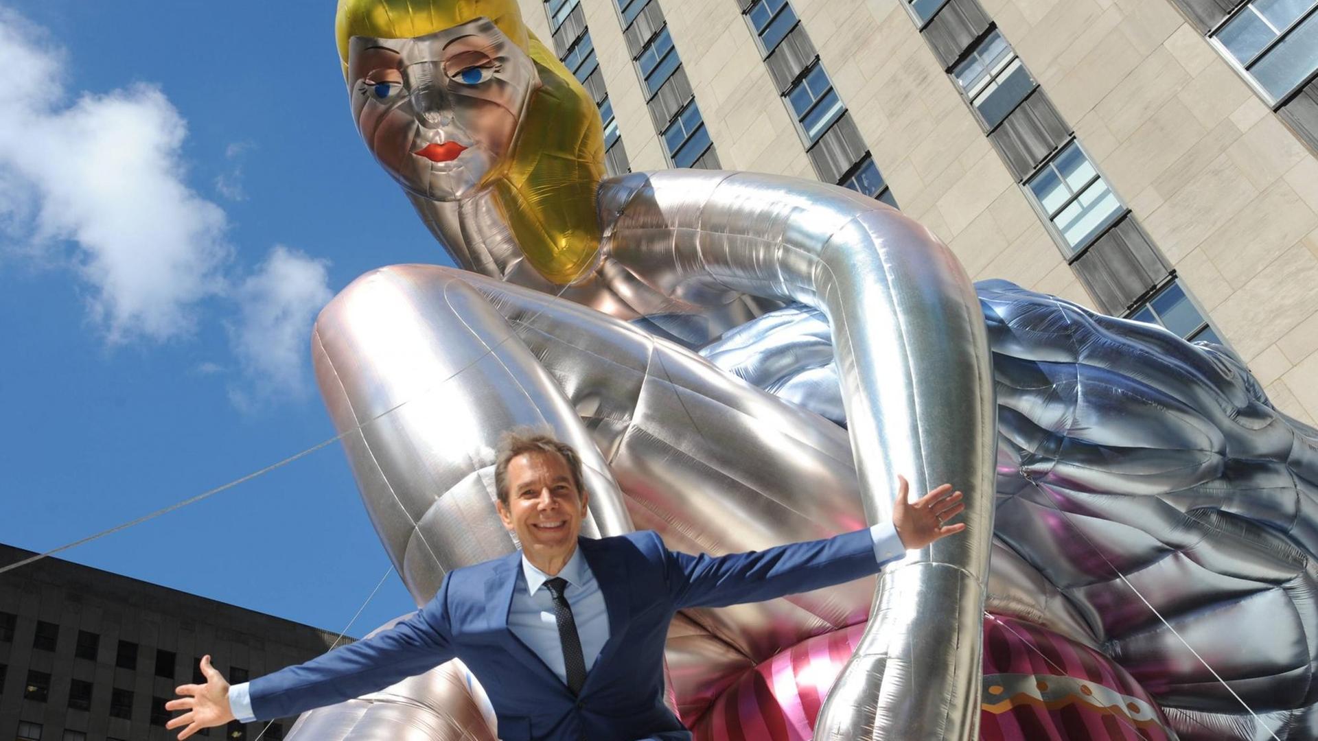 Jeff Koons vor seiner Ballerina. Er breitet die Arme aus. Jeff Koons vor seiner Ballerina. Er breitet die Arme aus.