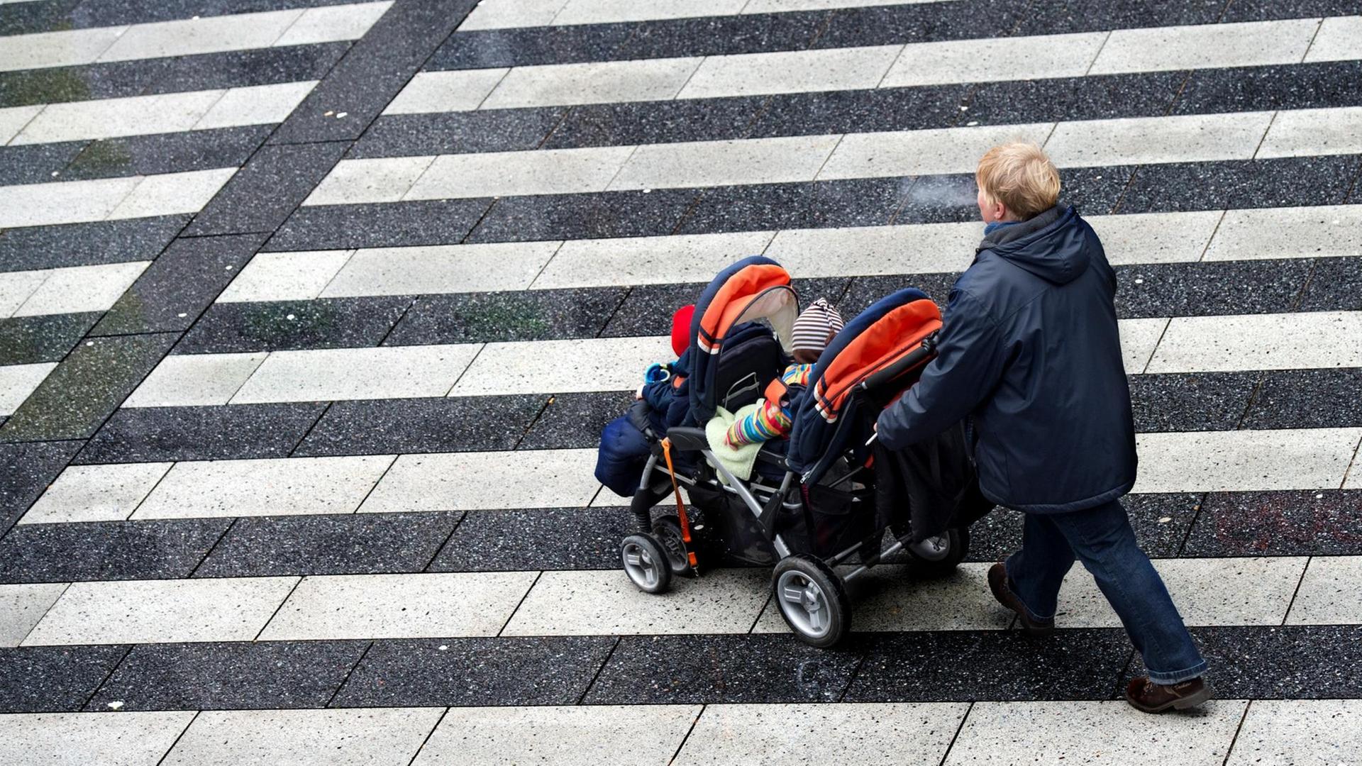 Eine Frau schiebt am 04.02.2013 einen Kinderwagen über den Raschplatz in Hannover (Niedersachsen). Eine Frau schiebt am 04.02.2013 einen Kinderwagen über den Raschplatz in Hannover (Niedersachsen).