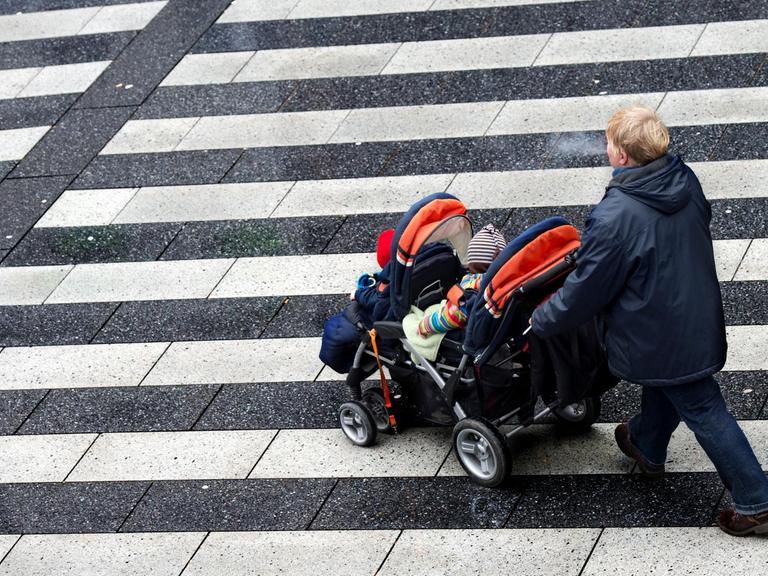 Eine Frau schiebt am 04.02.2013 einen Kinderwagen über den Raschplatz in Hannover (Niedersachsen).