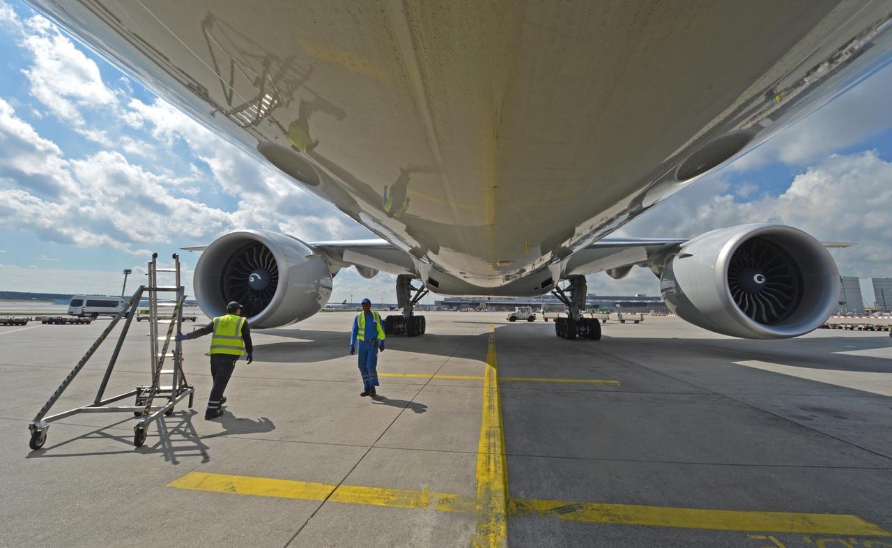 Eine Boeing 777 wird auf dem Rollfeld des Frankfurter Flughafens von Technikern gewartet. 