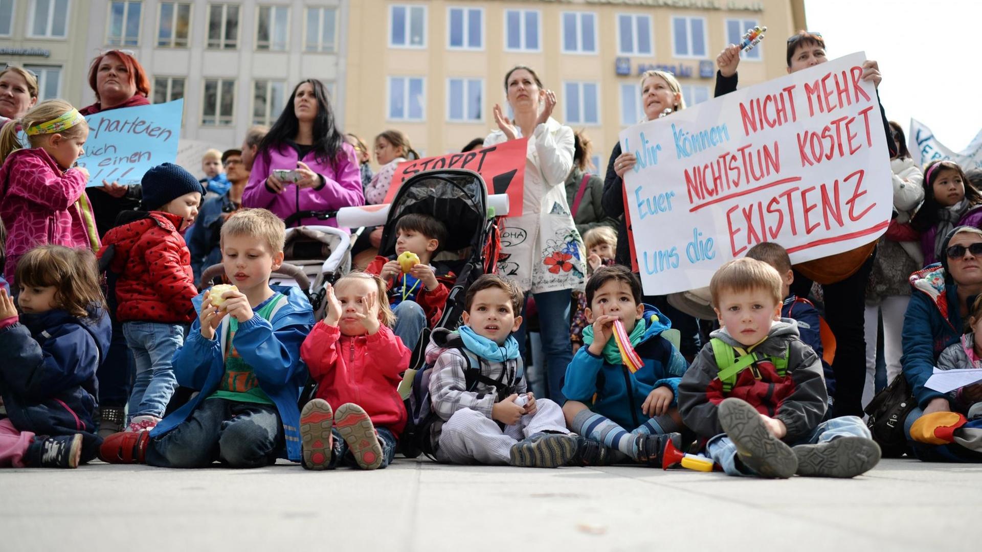 Eine Kundgebung von Eltern und Kindern gegen den Kita-Streik in München. Zwei Teilnehmerinnen halten ein Plakat mit der Aufschrift "Wir können nicht mehr. Euer Nichtstun kostet uns die Existenz" in Händen. Eine Kundgebung von Eltern und Kindern gegen den Kita-Streik in München. Zwei Teilnehmerinnen halten ein Plakat mit der Aufschrift "Wir können nicht mehr. Euer Nichtstun kostet uns die Existenz" in Händen.