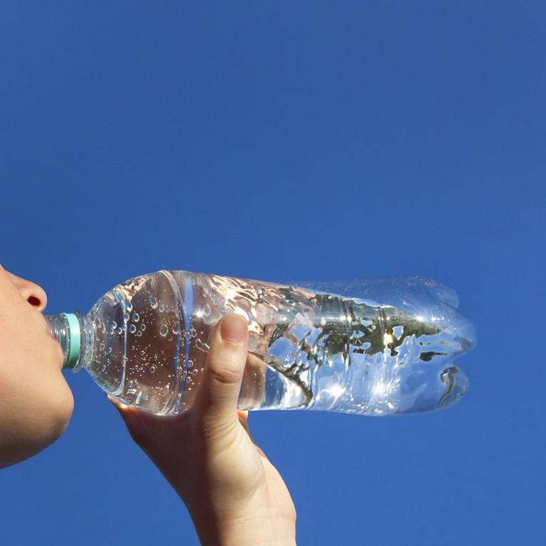 Frau trinkt Wasser aus einer Plastikflasche (Symbolbild)