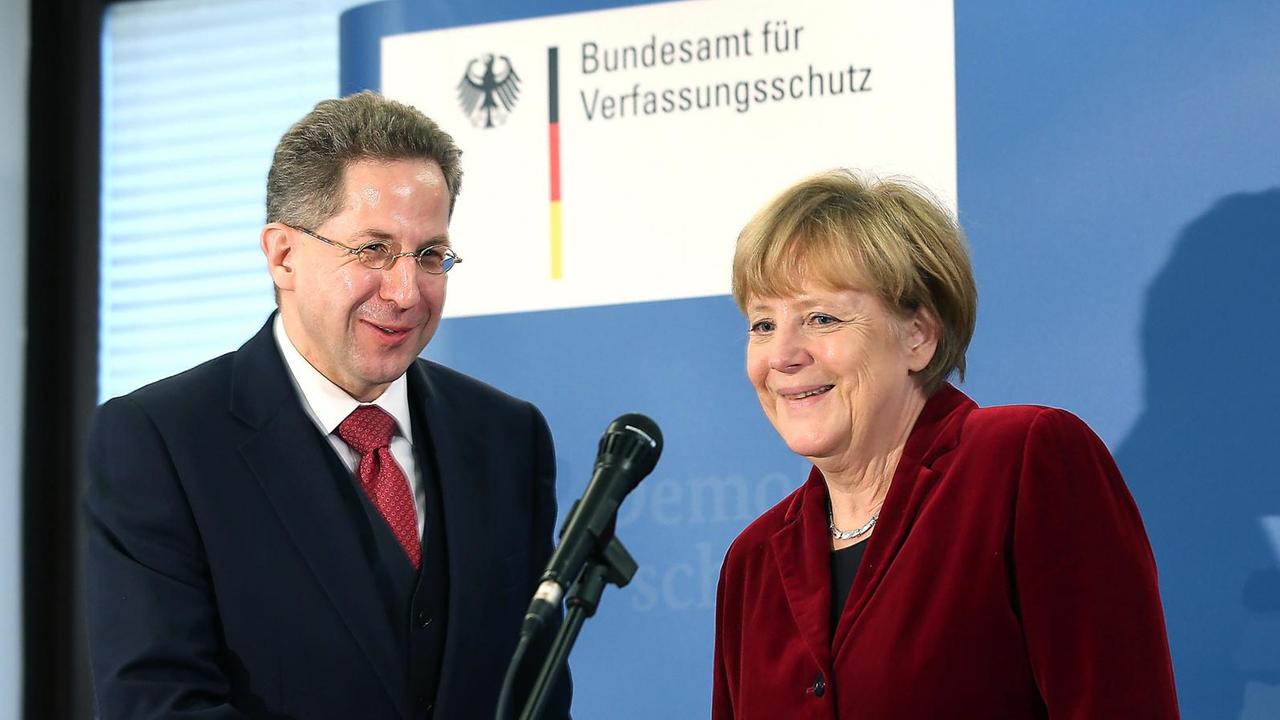 Der Präsident des Bundesamtes für Verfassungsschutz, Hans-Georg Maaßen (rl verabschiedet Bundeskanzlerin Angela Merkel (r) am 31.10.2014 in Köln (Nordrhein-Westfalen) im Bundesamt für Verfassungsschutz. Foto: Oliver Berg/dpa ++ Der Präsident des Bundesamtes für Verfassungsschutz, Hans-Georg Maaßen (rl verabschiedet Bundeskanzlerin Angela Merkel (r) am 31.10.2014 in Köln (Nordrhein-Westfalen) im Bundesamt für Verfassungsschutz. Foto: Oliver Berg/dpa ++