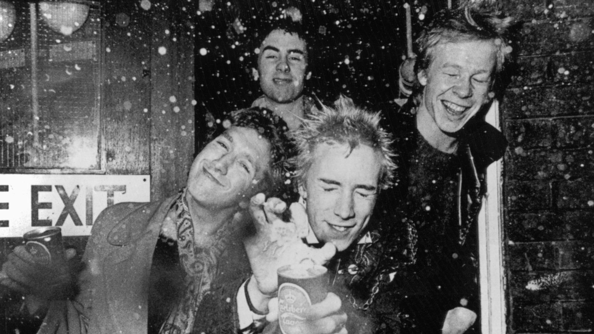 Die britische Punk-Rock-Band "Sex Pistols" . Vorne Steve Jones (l) und Bandleader und Sänger Jonny Rotten (M), dahinter Glen Matlock und Paul Cook (r). Die britische Punk-Rock-Band "Sex Pistols" . Vorne Steve Jones (l) und Bandleader und Sänger Jonny Rotten (M), dahinter Glen Matlock und Paul Cook (r).
