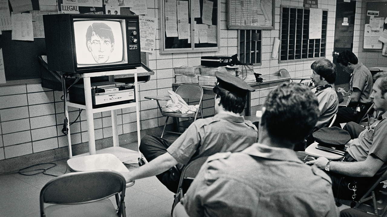 Polizisten sitzen vor einem Röhrenfernseher und schauen Phantombild an. Polizisten sitzen vor einem Röhrenfernseher und schauen Phantombild an.