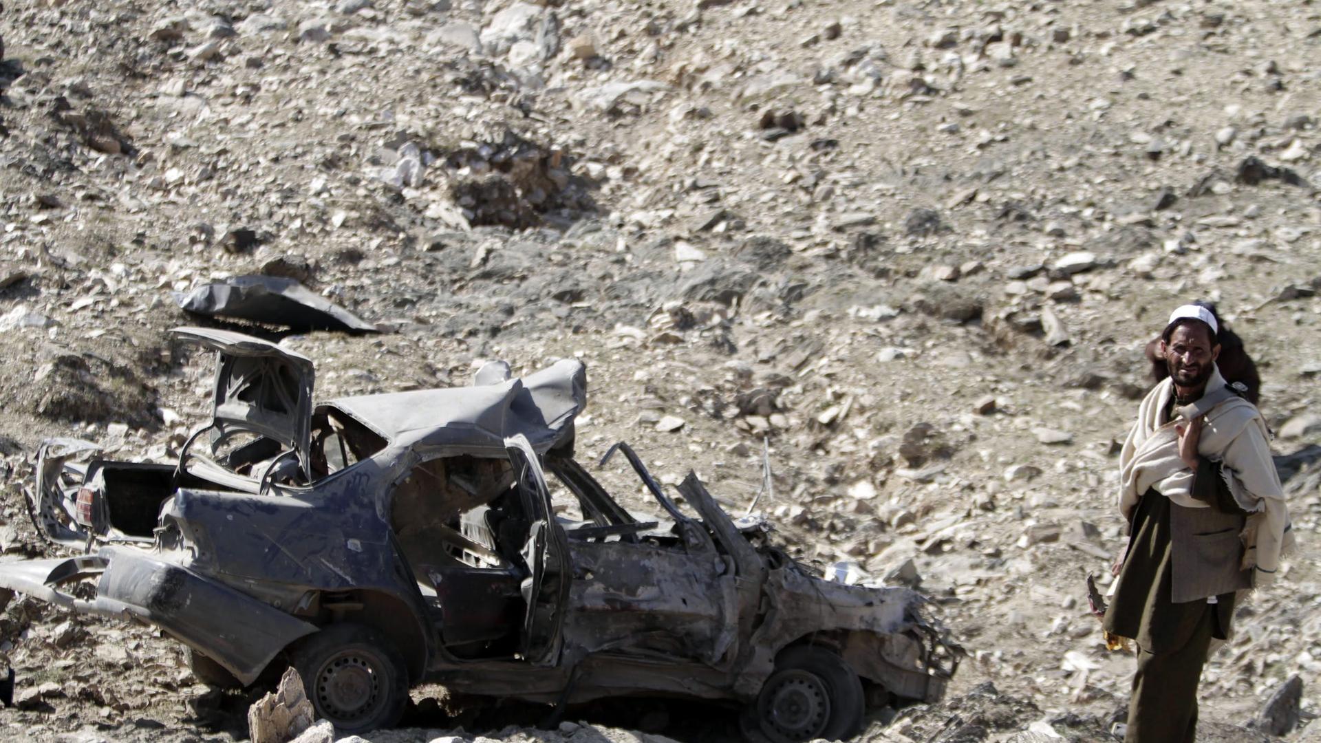 Afghanischer Mann untersucht eine Stelle, an der eine Autobombe explodiert ist (28.11.2013) Afghanischer Mann untersucht eine Stelle, an der eine Autobombe explodiert ist (28.11.2013)
