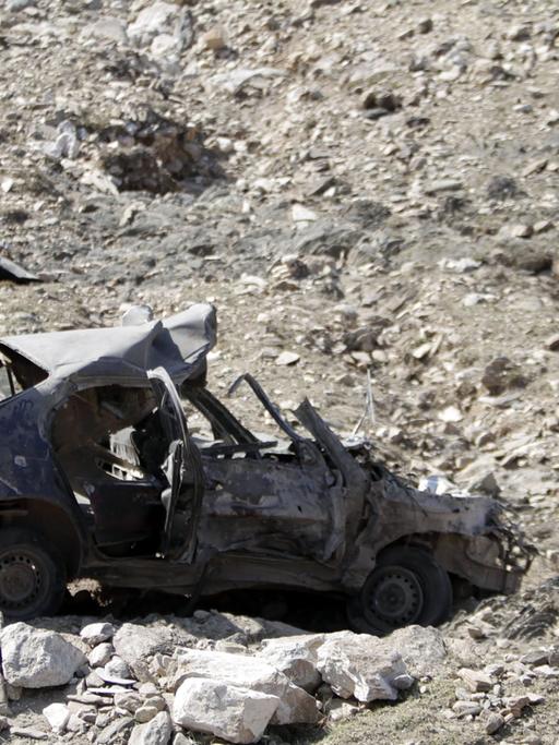 Afghanischer Mann untersucht eine Stelle, an der eine Autobombe explodiert ist (28.11.2013)