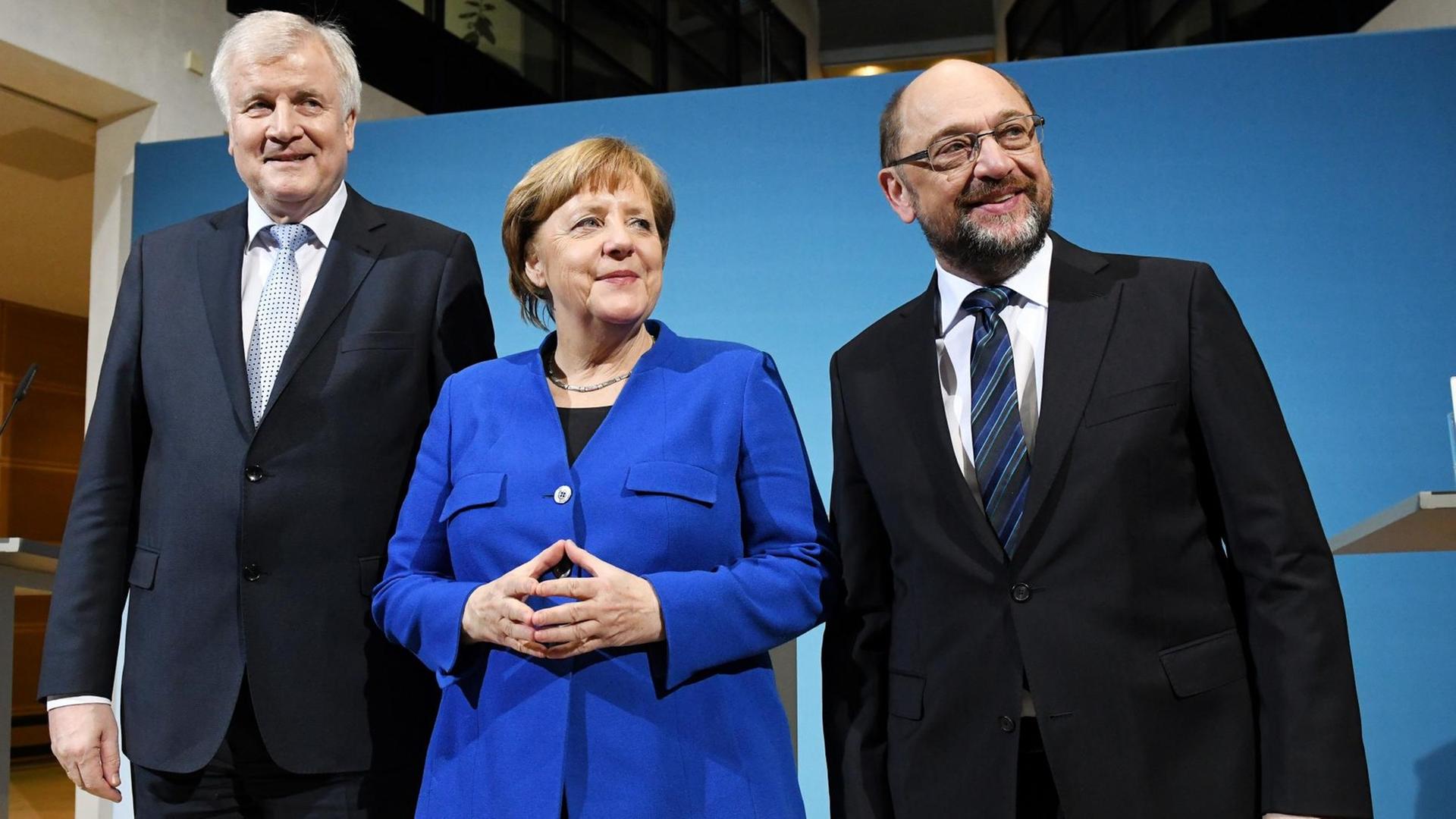 Der CSU-Vorsitzenden Horst Seehofer (l), der SPD-Parteivorsitzende Martin Schulz (r) und Bundeskanzlerin Angela Merkel (CDU) stellen sich am 12.01.2018 im Willy-Brandt-Haus in Berlin nach einer Pressekonferenz zu einem Foto auf. Die Spitzen von CDU, CSU und SPD streben eine Neuauflage der großen Koalition an.