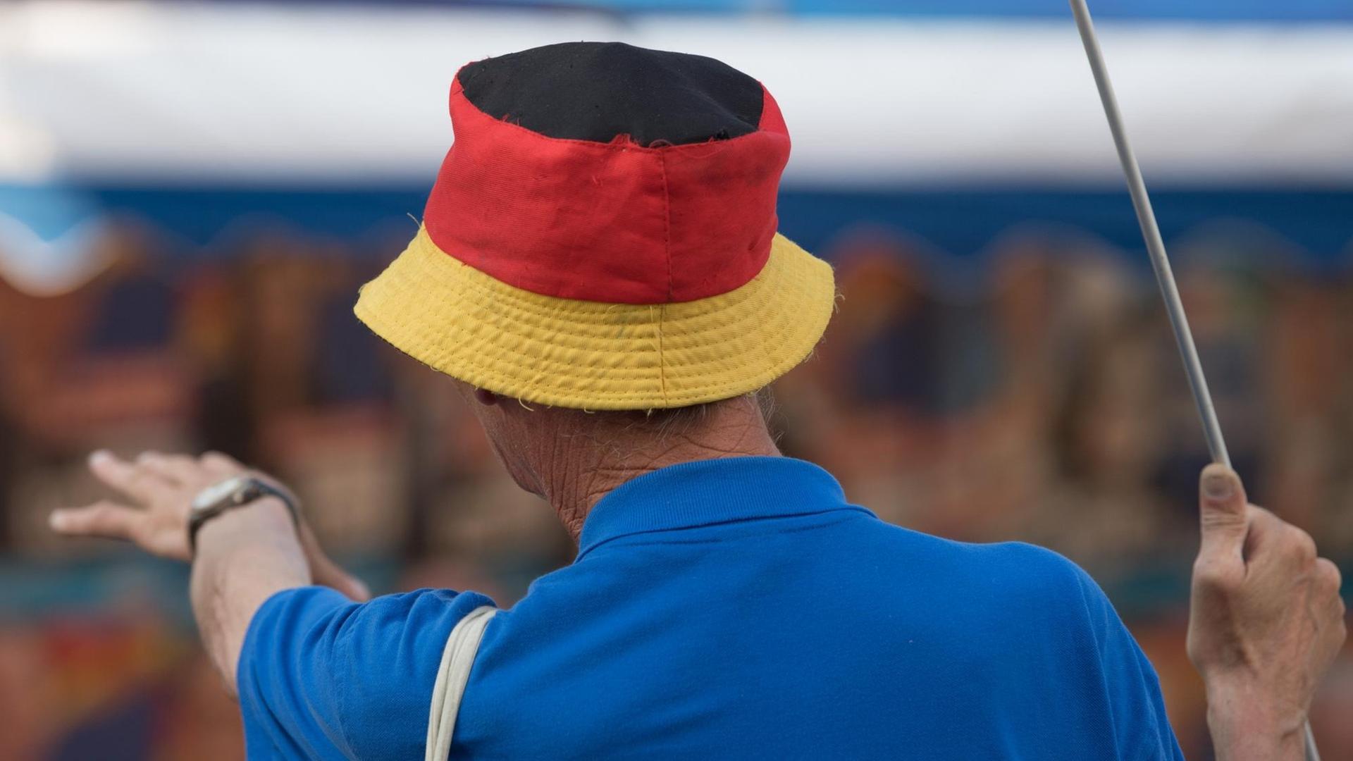 Ein Mann trägt am Rande einer Wahlkampfveranstaltung der AfD Sachsen ein blaues Polo-Shirt und einen Fischerhut in Deutschlandfarben. Ein Mann trägt am Rande einer Wahlkampfveranstaltung der AfD Sachsen ein blaues Polo-Shirt und einen Fischerhut in Deutschlandfarben.