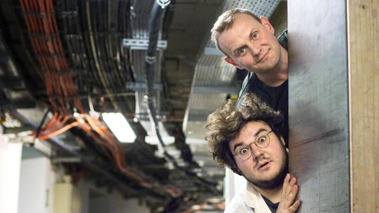 Devid Striesow und Axel Ranisch schaun hinter einem Eingang hervor. Devid Striesow und Axel Ranisch schaun hinter einem Eingang hervor.