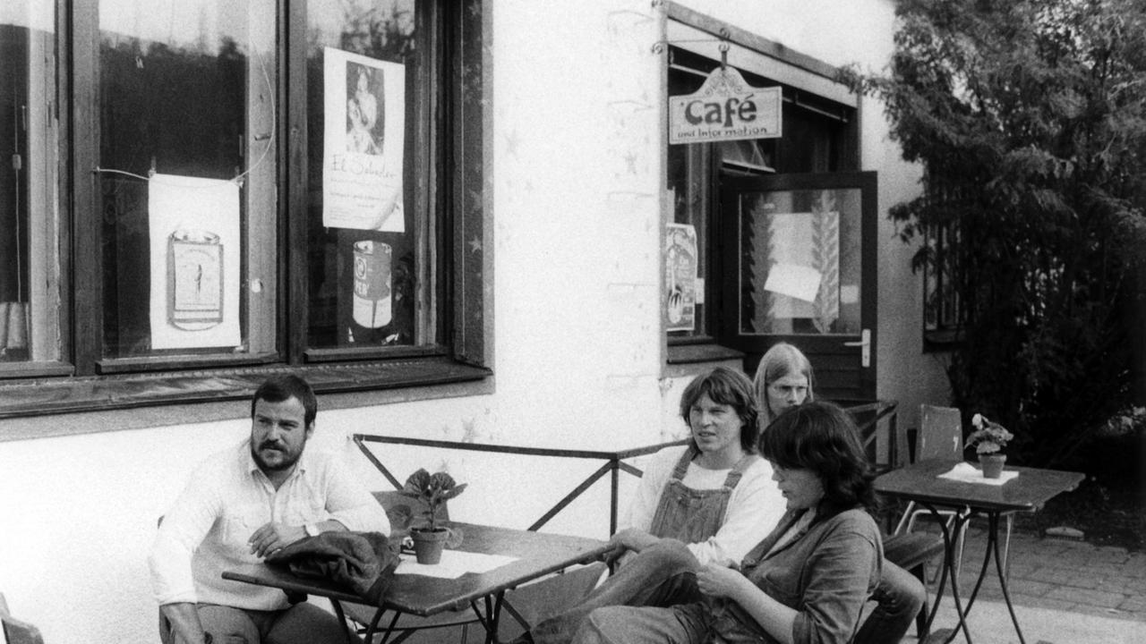 Menschen sitzen vor einem Café.