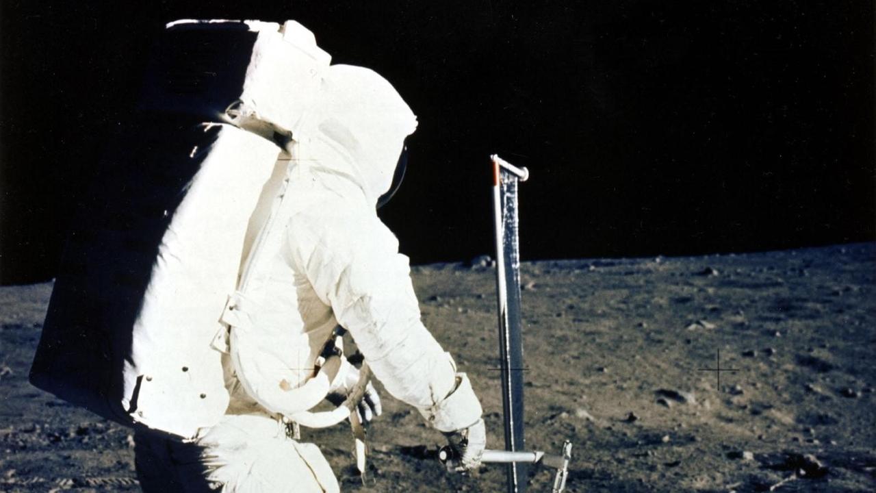 Astronaut Edwin E. Aldrin Jr. befestigt eine Solarwind-Experiment auf dem Mond während der Apollo 11-Mission. Astronaut Edwin E. Aldrin Jr. befestigt eine Solarwind-Experiment auf dem Mond während der Apollo 11-Mission.
