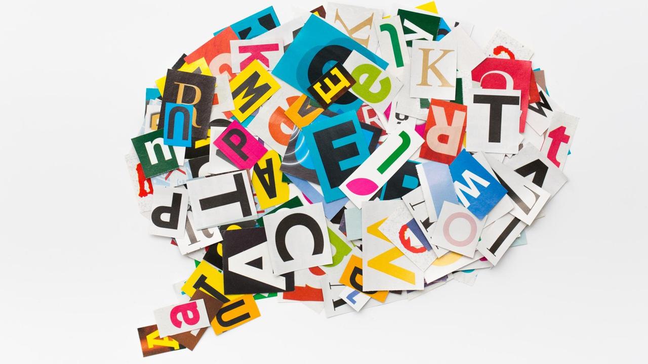In einer Sprachblase sind ausgeschnittene, bunte Buchstaben völlig durcheinander angeordnet. In einer Sprachblase sind ausgeschnittene, bunte Buchstaben völlig durcheinander angeordnet.