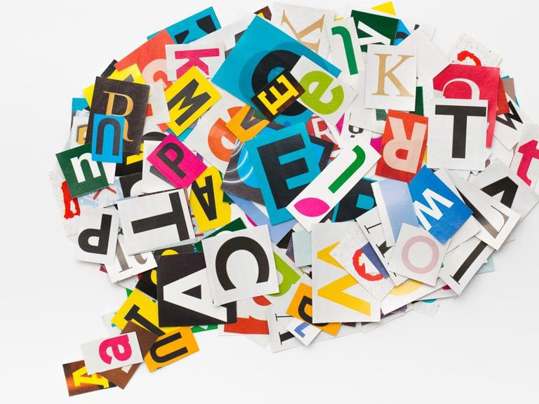 In einer Sprachblase sind ausgeschnittene, bunte Buchstaben völlig durcheinander angeordnet.