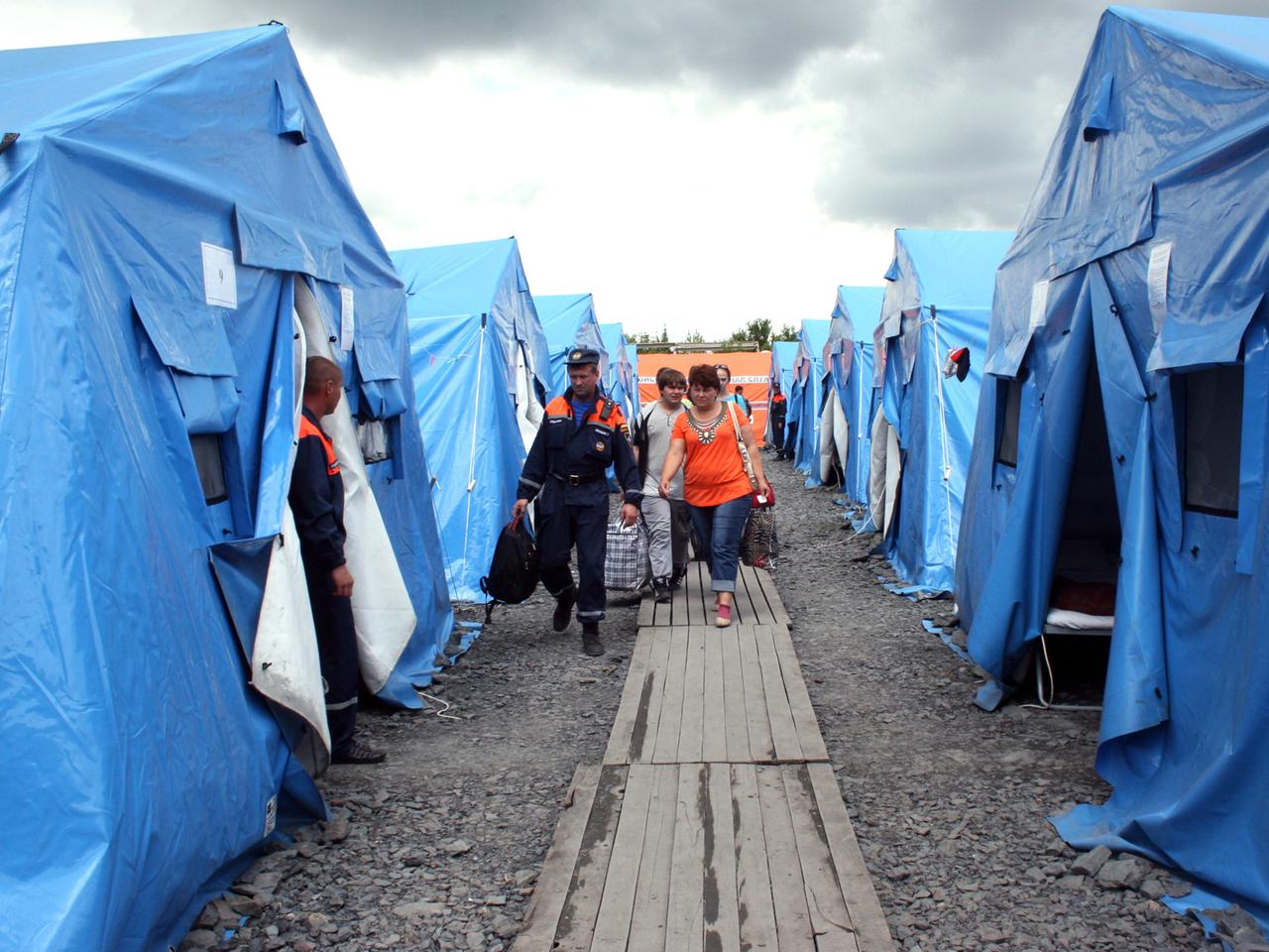Neuankömmlinge aus dem Konfliktgebiet Ostukraine werden am 09.07.2014 von russischen Helfern im Flüchtlingslager in Nowoschachtinsk zu Zelten gebracht. Neuankömmlinge aus dem Konfliktgebiet Ostukraine werden am 09.07.2014 von russischen Helfern im Flüchtlingslager in Nowoschachtinsk zu Zelten gebracht.