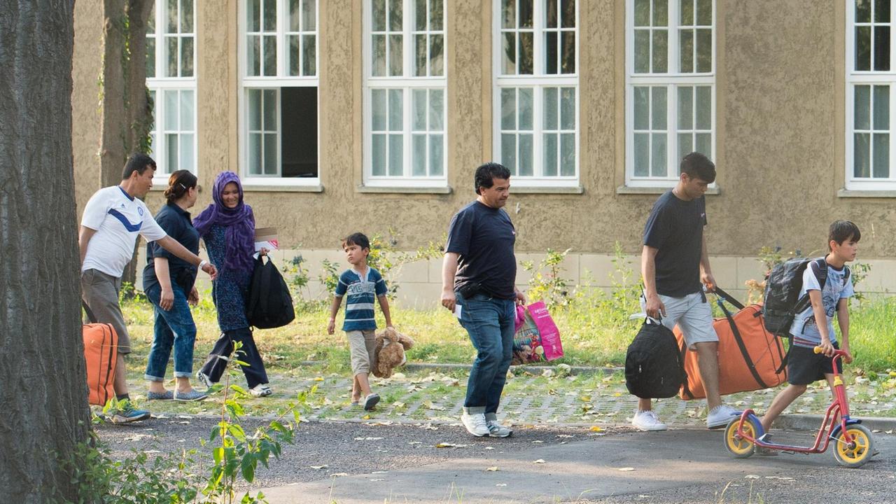Flüchtlinge laufen an einer Erstaufnahmeeinrichtung entlang Flüchtlinge laufen an einer Erstaufnahmeeinrichtung entlang