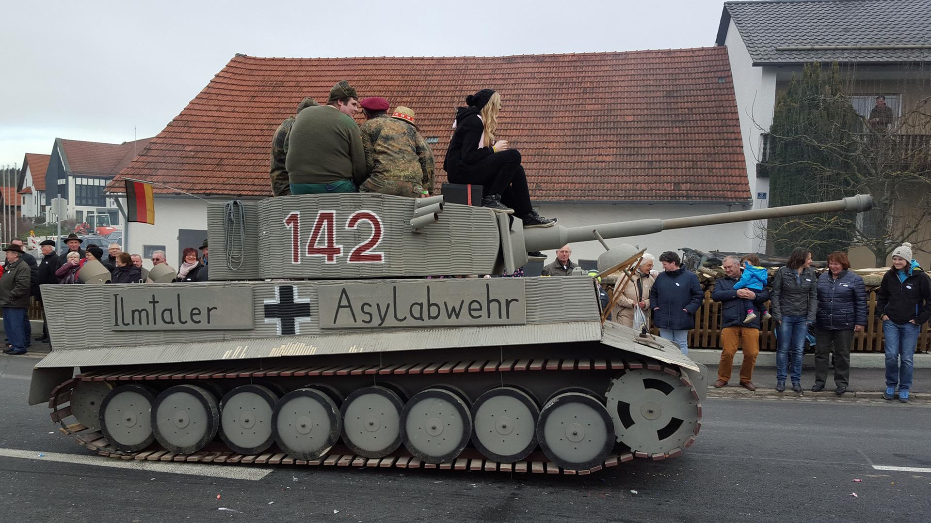 Ein Panzer mit der Aufschrift "Ilmtaler Asylabwehr" nimmt am 7. Februar 2016 an einem Faschingsumzug in Reichertshausen im Landkreis Pfaffenhofen in Bayern teil Die Behörden ermitteln nun wegen des Verdachts der Volksverhetzung. Ein Panzer mit der Aufschrift "Ilmtaler Asylabwehr" nimmt am 7. Februar 2016 an einem Faschingsumzug in Reichertshausen im Landkreis Pfaffenhofen in Bayern teil Die Behörden ermitteln nun wegen des Verdachts der Volksverhetzung.