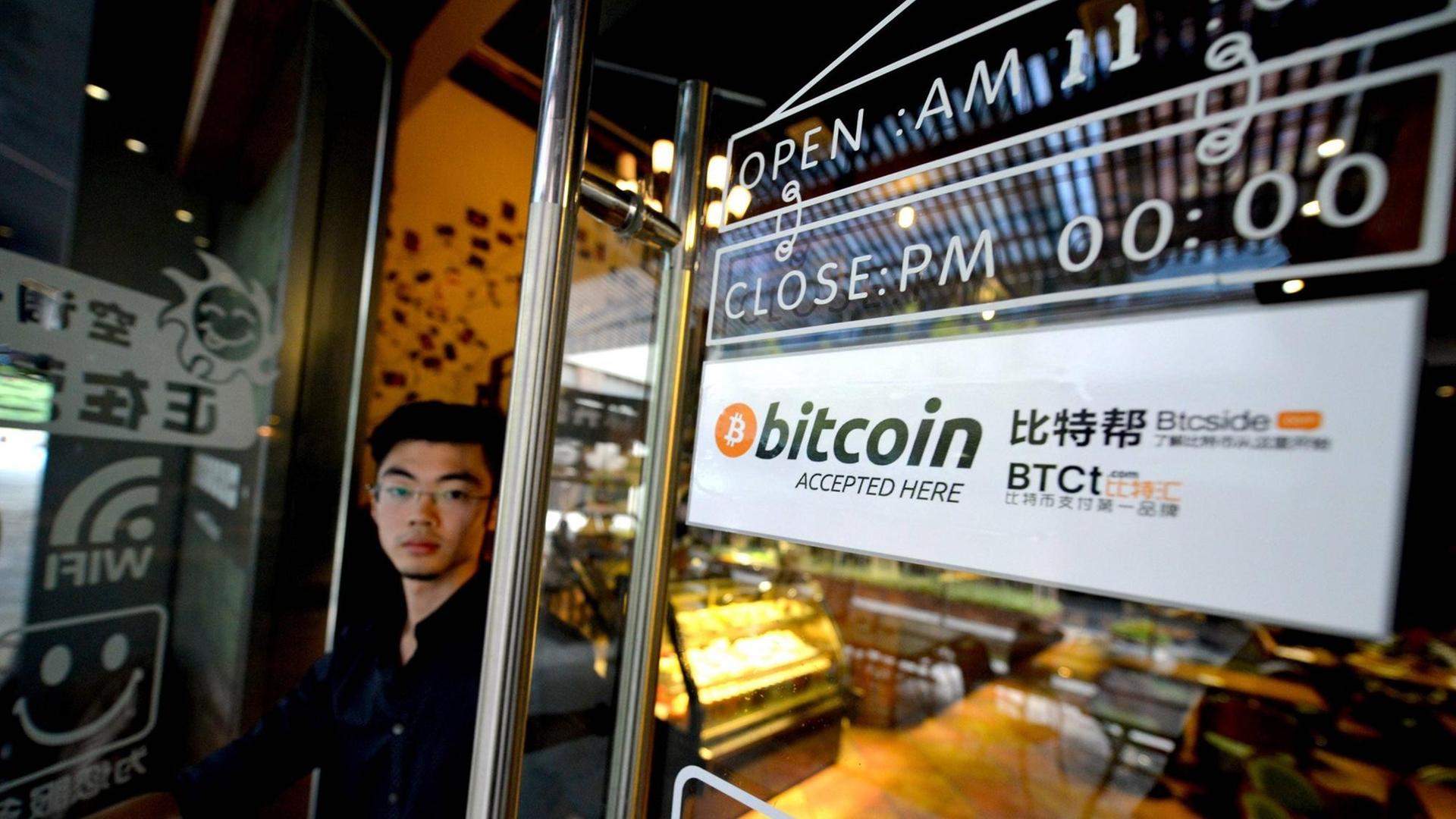 Am Fenster eines Coffeeshops in Nanshan in China hängt ein Schild, das Kunden darüber informiert, dass hier auch mit der digitalen Währung Bitcoin bezahlt werden kann.