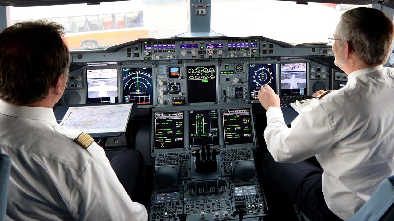Zwei Piloten arbeiten am 05.06.2014 auf dem Flughafen in Hamburg im Cockpit eines Lufthansa-Airbus A380. Zwei Piloten arbeiten am 05.06.2014 auf dem Flughafen in Hamburg im Cockpit eines Lufthansa-Airbus A380.