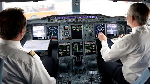 Zwei Piloten arbeiten am 05.06.2014 auf dem Flughafen in Hamburg im Cockpit eines Lufthansa-Airbus A380.
