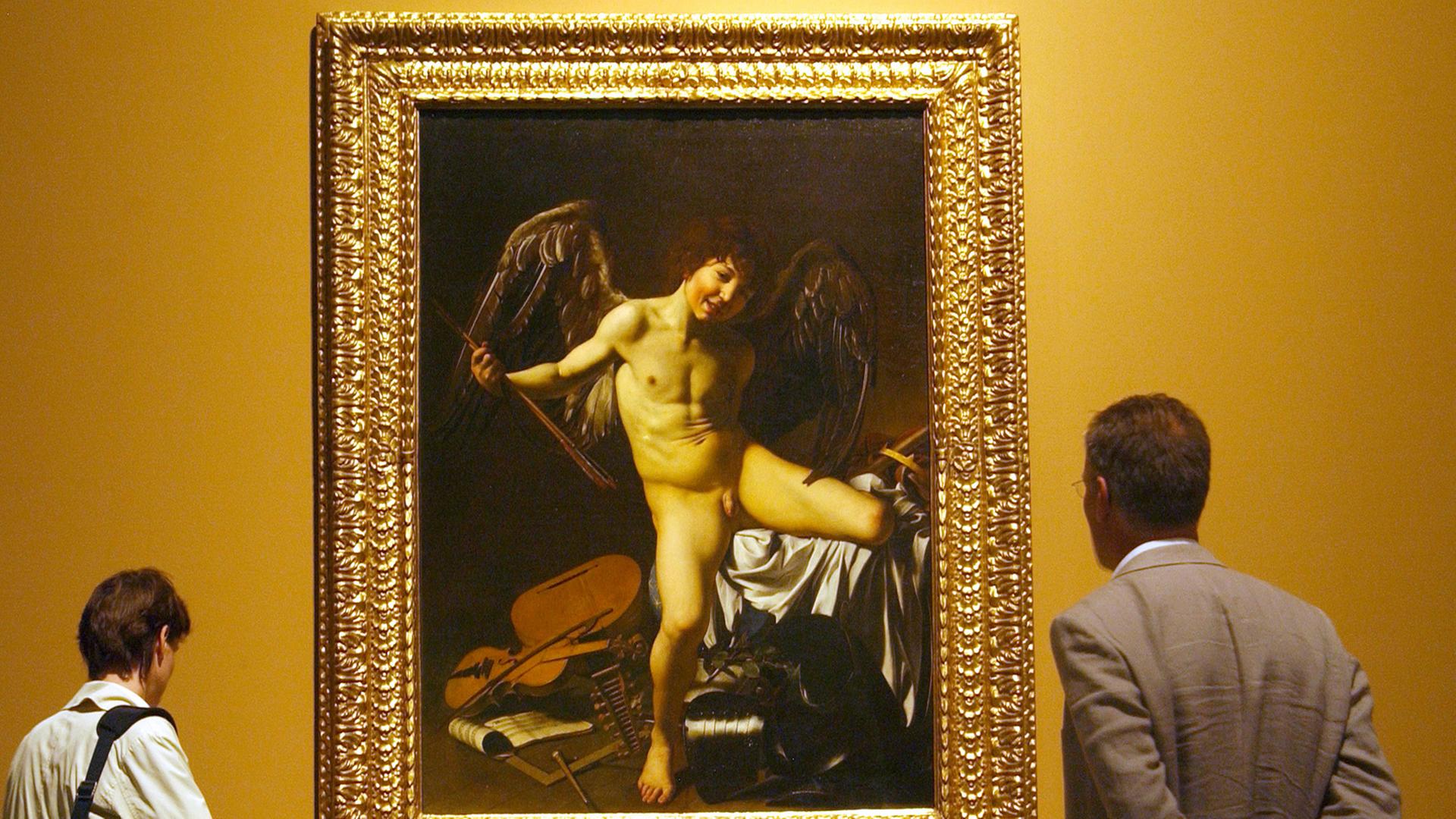 Vor dem Bild "Amor als Sieger" des italienischen Barockkünstlers Michelangelo Merisi, besser bekannt als Caravaggio (1571-1610), stehen Betrachter am Freitag (08.09.2006) in Düsseldorf im Museum Kunstpalast bei einem Presserundgang.