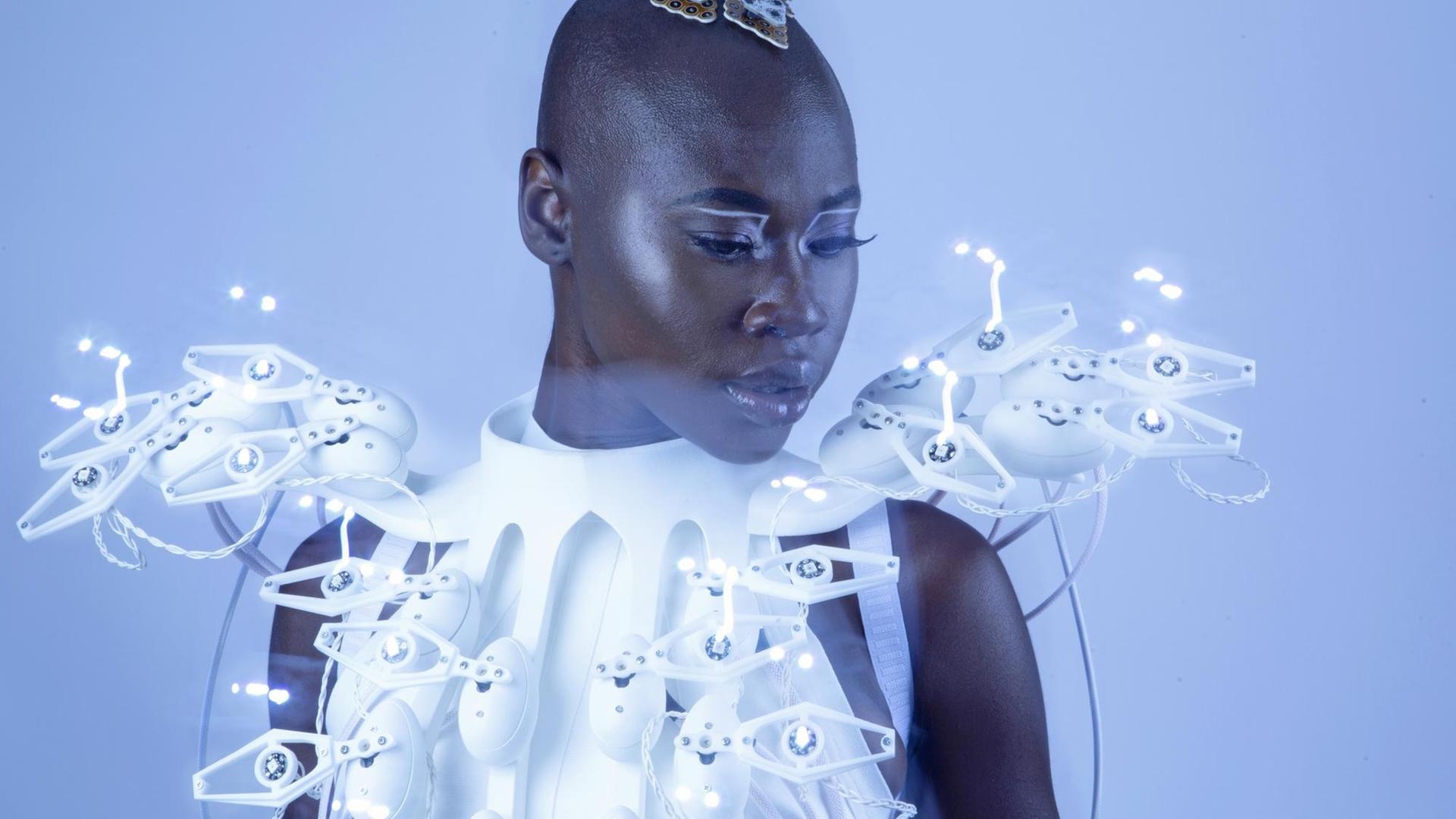 Auf dem Bild ist das futuristische anmutende weiße Kleid der Designerin Anouk Wipprecht zu sehen. Es hat seltsame Sensoren, die sich von ihm abheben. Auf dem Bild ist das futuristische anmutende weiße Kleid der Designerin Anouk Wipprecht zu sehen. Es hat seltsame Sensoren, die sich von ihm abheben.