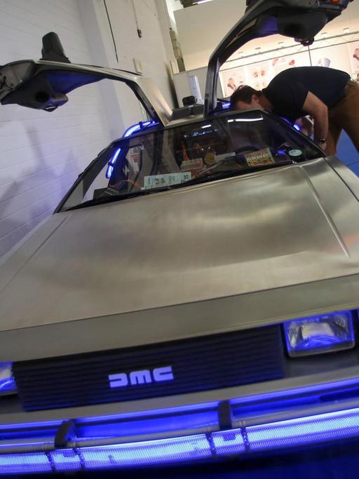 An einem kleinen Foto-Stand steht auf der Internationalen Automobil-Ausstellung (IAA) in Frankfurt am Main (Hessen) ein originaler, von den Universal Studios umgebauter Delorean (ein DeLorean Motor Company (DMC) 12 aus dem Film «Zurück in die Zukunft»).