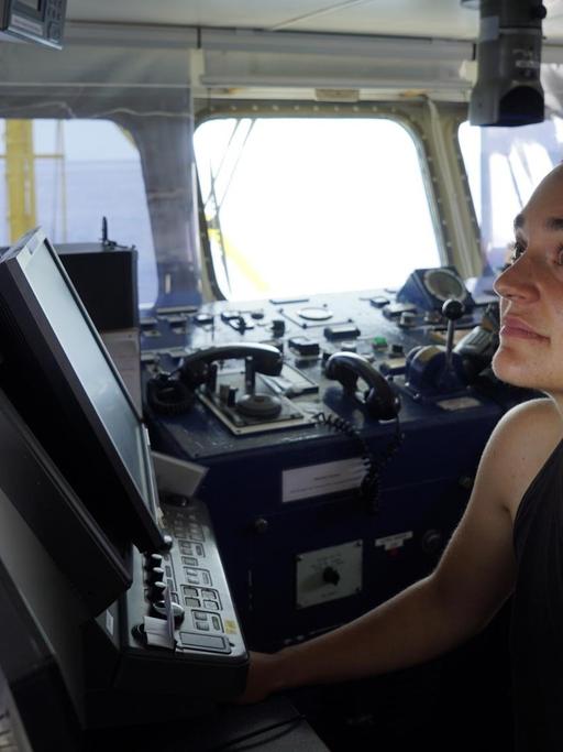 Die Kapitänin Carola Rackete steht auf der Brücke der "Sea-Watch" und schaut auf die Geräte.