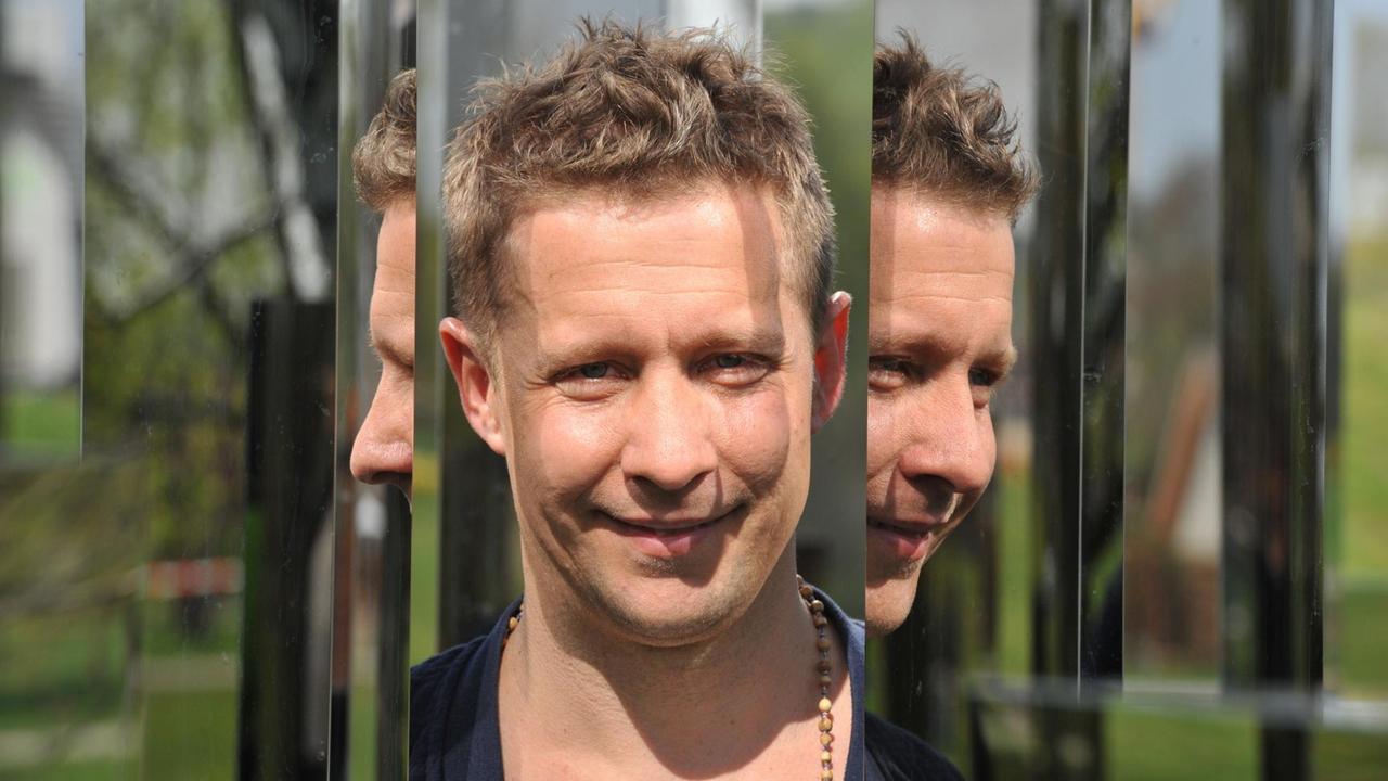 Der Künstler Jeppe Hein steht zwischen zwei spiegelnden Stelen. Der Künstler Jeppe Hein steht zwischen zwei spiegelnden Stelen.
