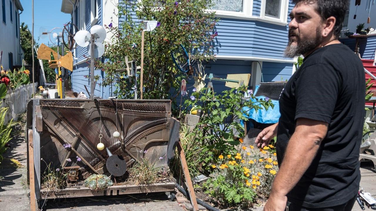 Der Instrumentenbauer Sudhi Tewari vor seinem "Straßenklavier" und diversen Windinstrumenten an seinem Haus in Berkeley.
