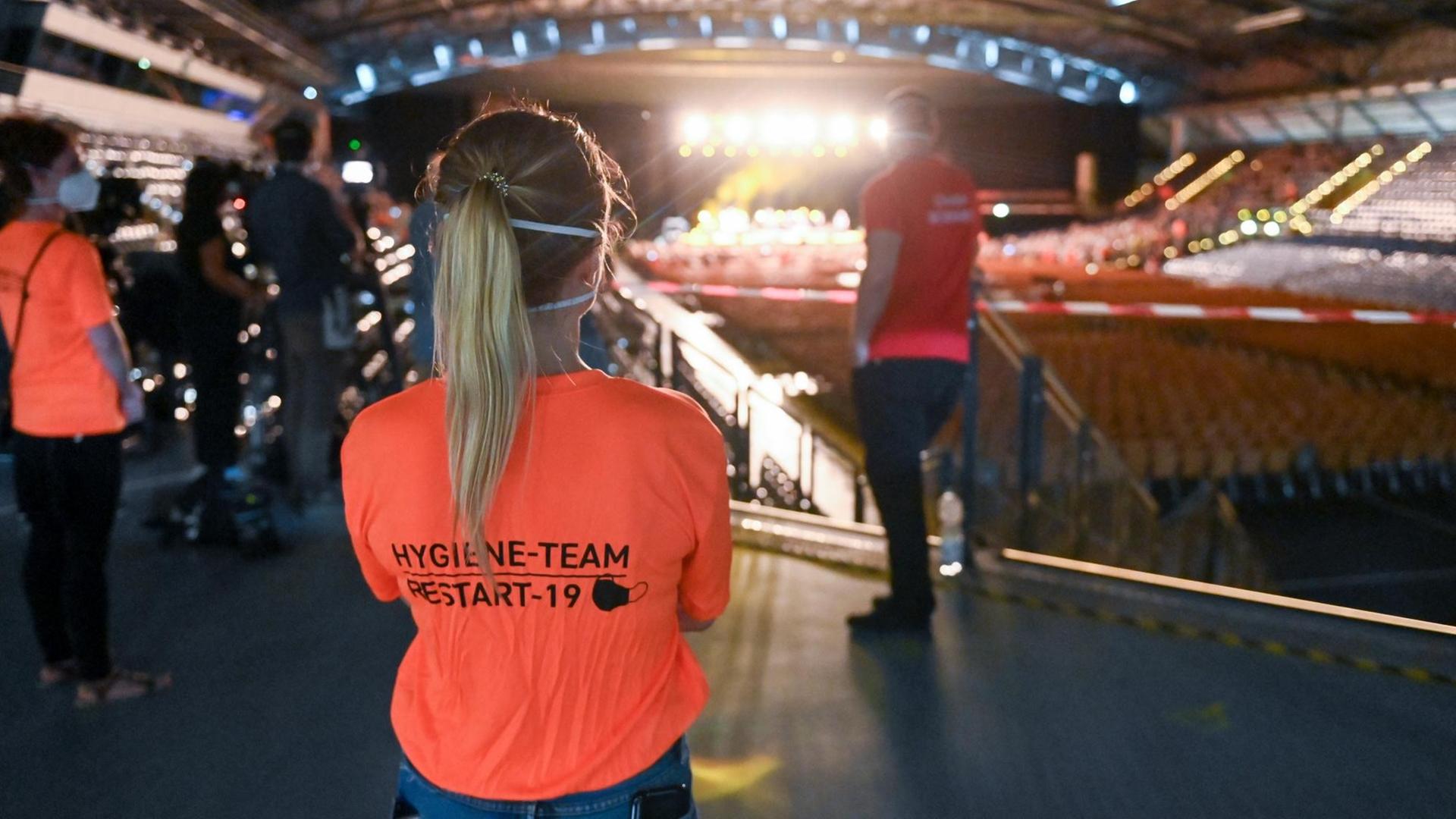 22.08.2020, Sachsen, Leipzig: Helfer aus dem Hygiene-Team verfolgen während eines Großversuchs der Universitätsmedizin Halle/Saale in der Arena Leipzig ein Konzert des Sängers Tim Bendzko. Foto: Hendrik Schmidt/dpa-Zentralbild/ZB | Verwendung weltweit 22.08.2020, Sachsen, Leipzig: Helfer aus dem Hygiene-Team verfolgen während eines Großversuchs der Universitätsmedizin Halle/Saale in der Arena Leipzig ein Konzert des Sängers Tim Bendzko. Foto: Hendrik Schmidt/dpa-Zentralbild/ZB | Verwendung weltweit