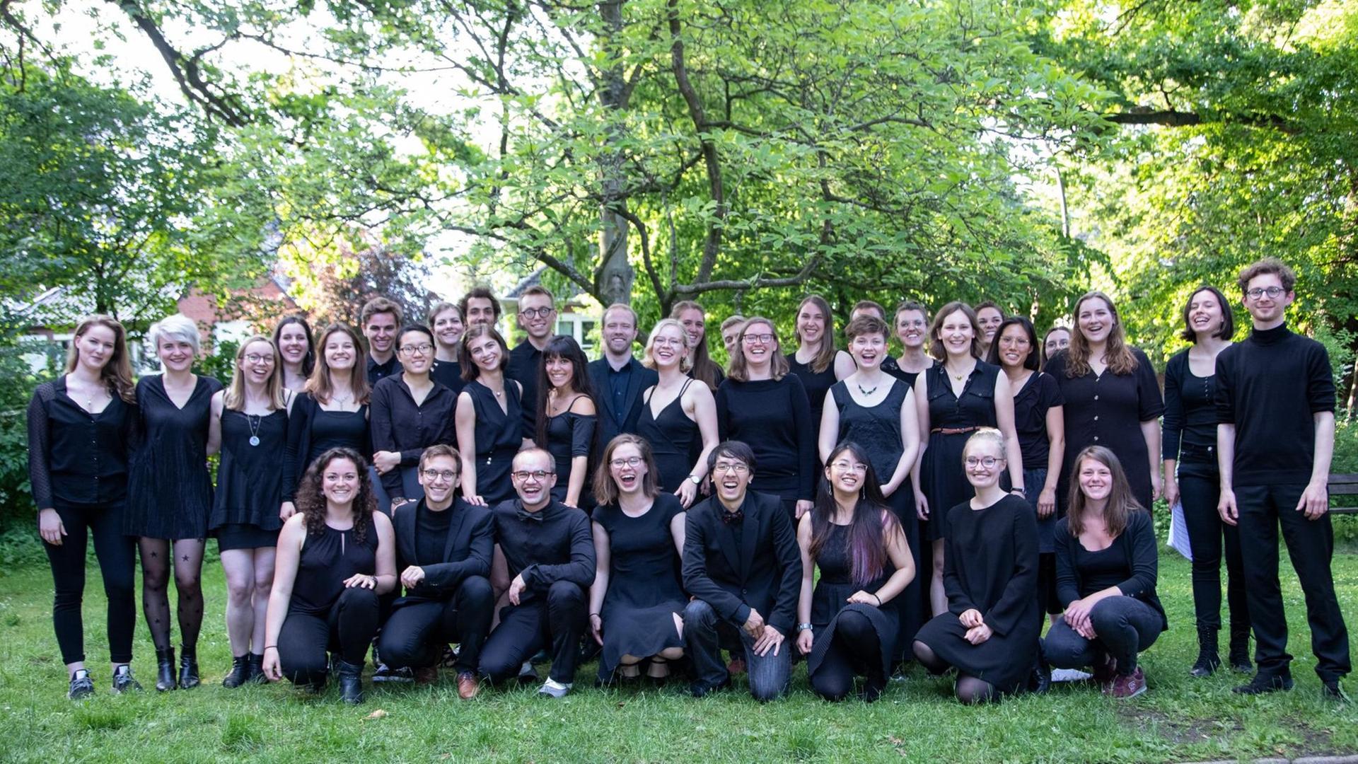 Das Bild zeigt ein Gruppenbild des Chores in einem Park. Das Bild zeigt ein Gruppenbild des Chores in einem Park.
