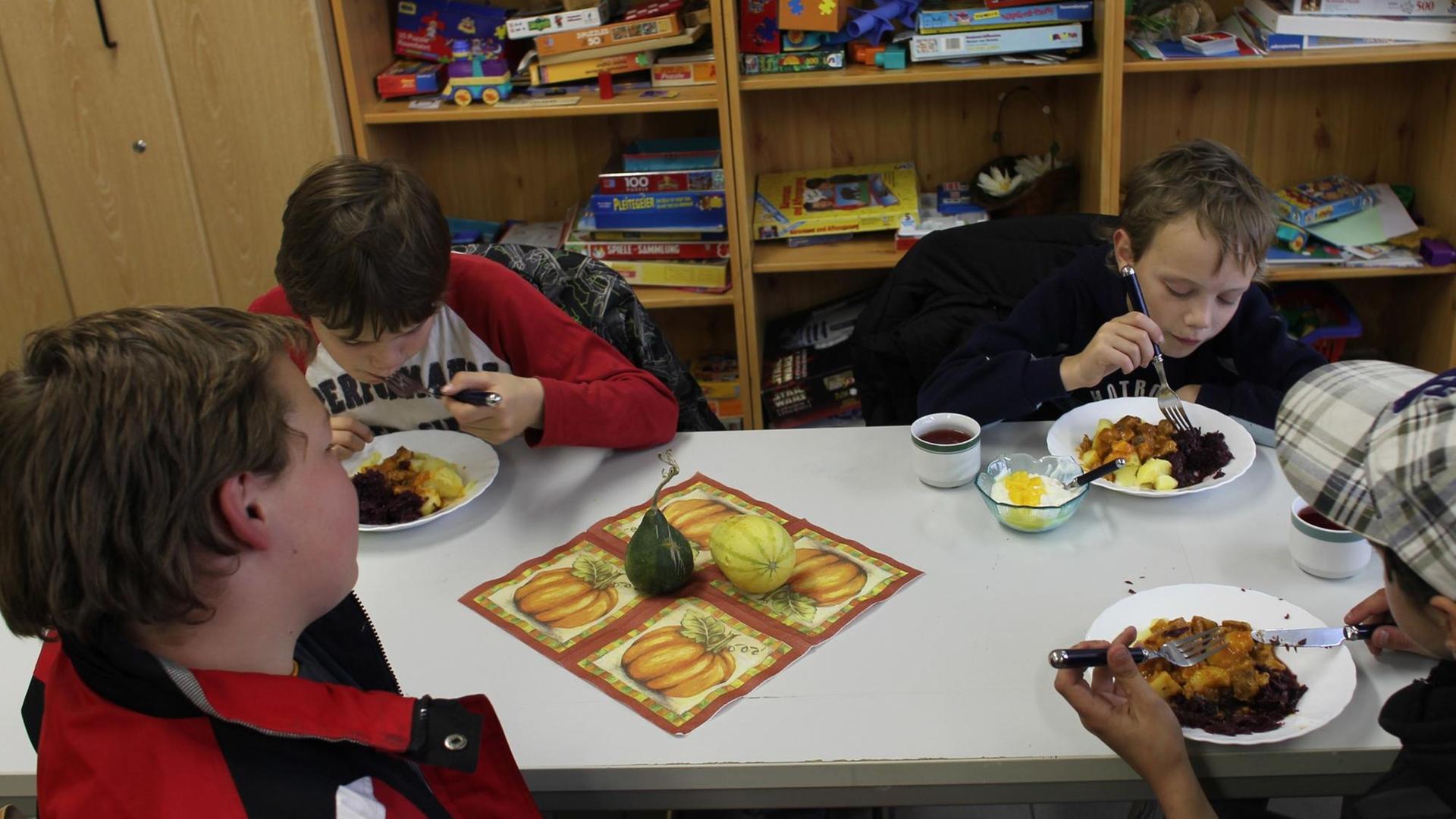 Kinder bekommen eine kostenlose warme Mahlzeit in einer Kindertagesstätte.