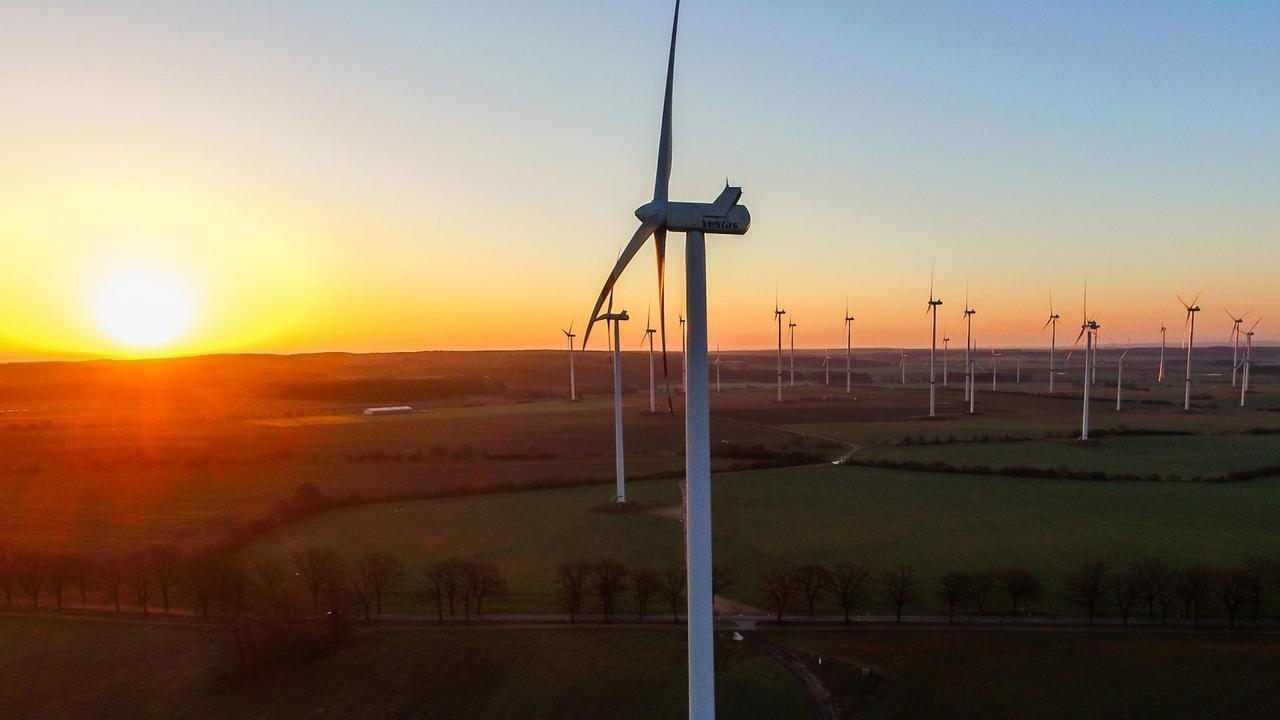 Das Luftbild zeigt kurz nach Sonnenaufgang einen Windenergiepark nahe Petersdorf in Brandenburg.