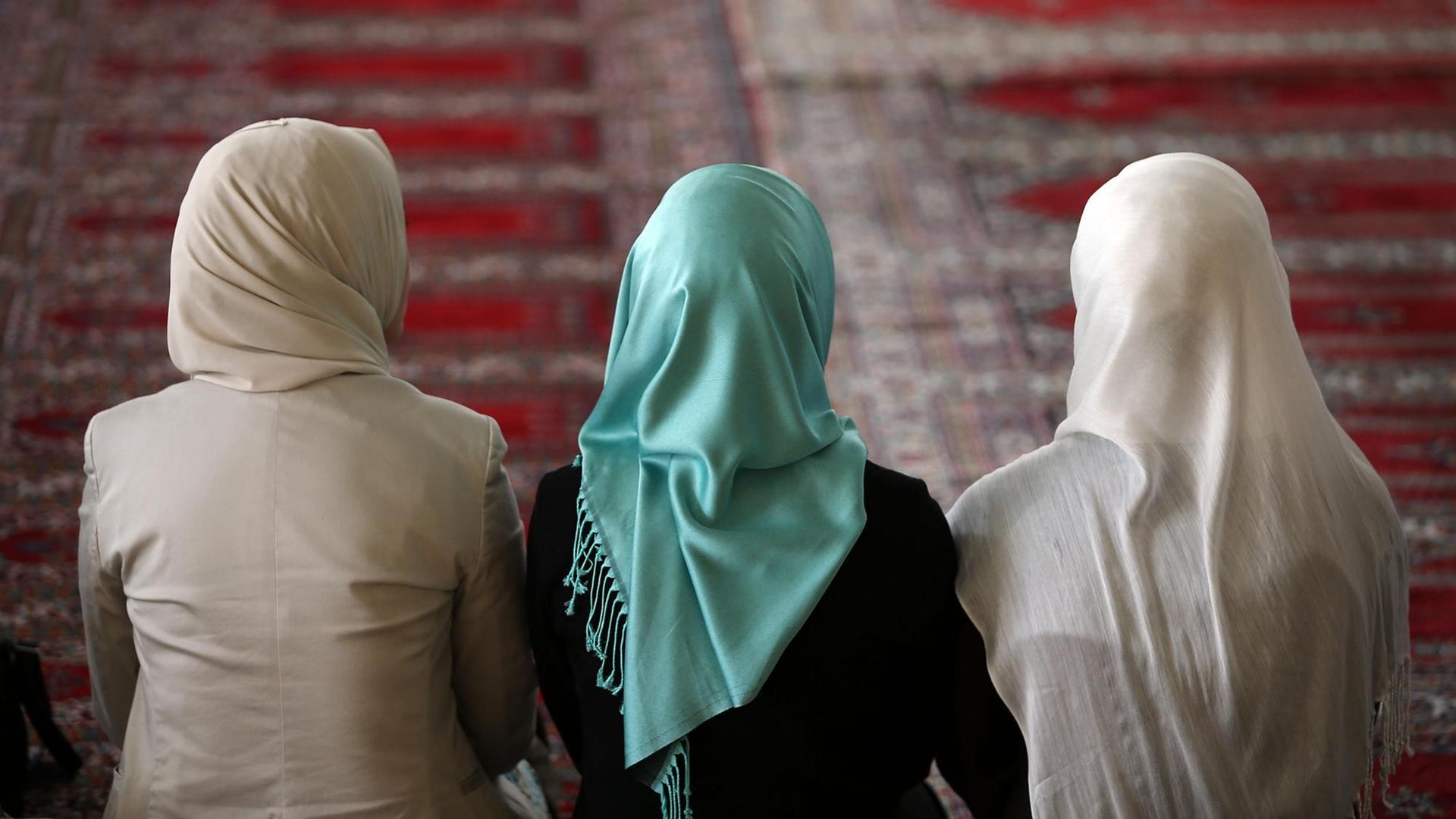 Muslimische Frauen sitzen in Köln (Nordrhein-Westfalen) in der Moschee mit Kopftüchern auf dem Gebetsteppich.
