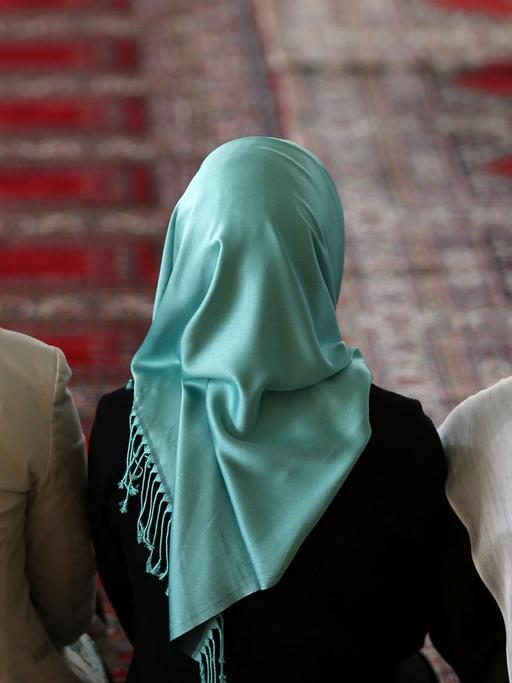 Muslimische Frauen sitzen in Köln (Nordrhein-Westfalen) in der Moschee mit Kopftüchern auf dem Gebetsteppich.