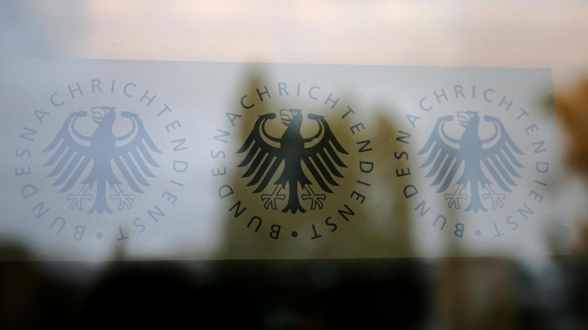 Das Logo des Bundesnachrichtendienstes durch eine Glastür betrachtet. Das Logo des Bundesnachrichtendienstes durch eine Glastür betrachtet.