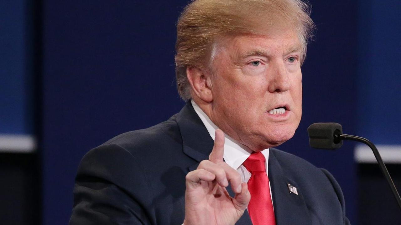 Donald Trump steht in der letzten TV-Debatte zwischen den Präsidentschaftsbewerbern im US-Wahlkampfes am Rednerpult. Donald Trump steht in der letzten TV-Debatte zwischen den Präsidentschaftsbewerbern im US-Wahlkampfes am Rednerpult.