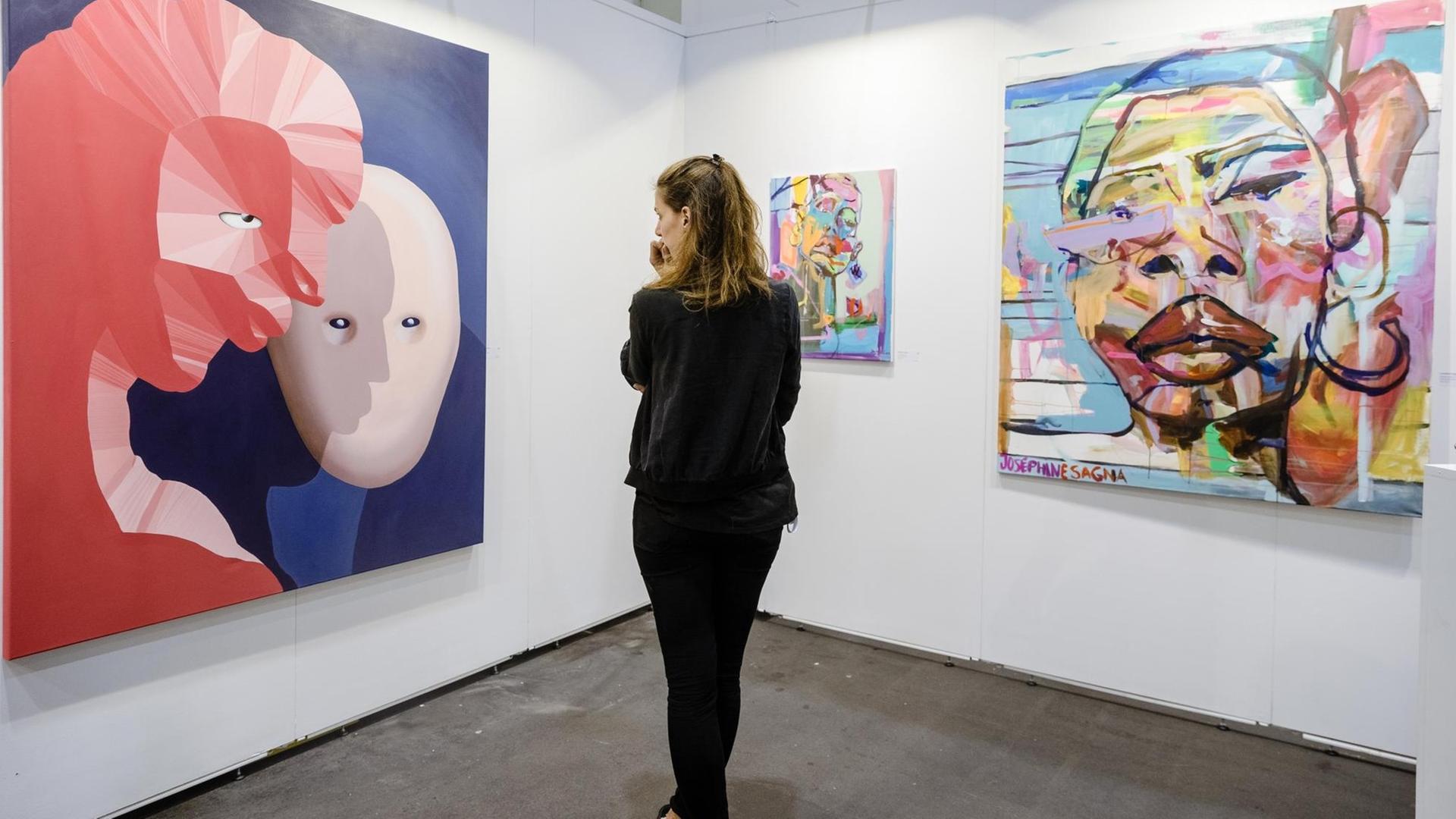 14.11.2018, Hamburg: Das Bild "Der Kuss" (l.) der Malerin Cathrin Hoffmann hängt am Stand einer Galerie auf der Messe Affordable Art Fair. Die Kunstmesse bietet Werke von Newcomern und etablierten Künstlern zu fairen Preisen, sie dauert vom 15. bis zum 18. November 2018. Die Werke, die auf der Messe zum Kauf angeboten werden, kosten zwischen 100 und 7.500 Euro. Foto: Markus Scholz/dpa | Verwendung weltweit 14.11.2018, Hamburg: Das Bild "Der Kuss" (l.) der Malerin Cathrin Hoffmann hängt am Stand einer Galerie auf der Messe Affordable Art Fair. Die Kunstmesse bietet Werke von Newcomern und etablierten Künstlern zu fairen Preisen, sie dauert vom 15. bis zum 18. November 2018. Die Werke, die auf der Messe zum Kauf angeboten werden, kosten zwischen 100 und 7.500 Euro. Foto: Markus Scholz/dpa | Verwendung weltweit
