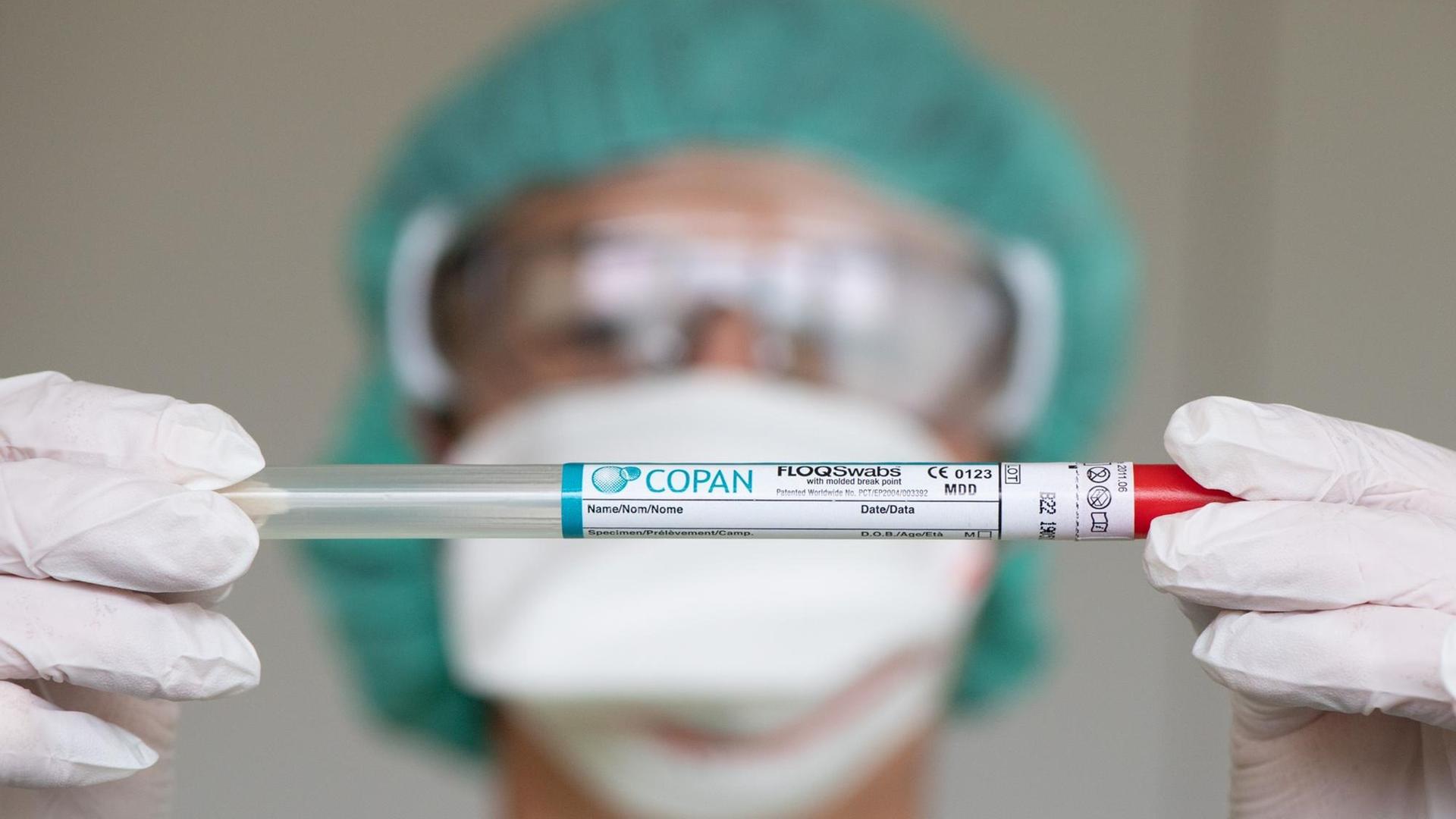 13.03.2020, Sachsen, Meißen: Katrin Zscherper, Stationsleitung Notfallaufnahme, hält in der Infektions-Ambulanz des Elblandklinikum Meißen ein Abstrichstäbchen im Plastikröhrchen. 13.03.2020, Sachsen, Meißen: Katrin Zscherper, Stationsleitung Notfallaufnahme, hält in der Infektions-Ambulanz des Elblandklinikum Meißen ein Abstrichstäbchen im Plastikröhrchen.
